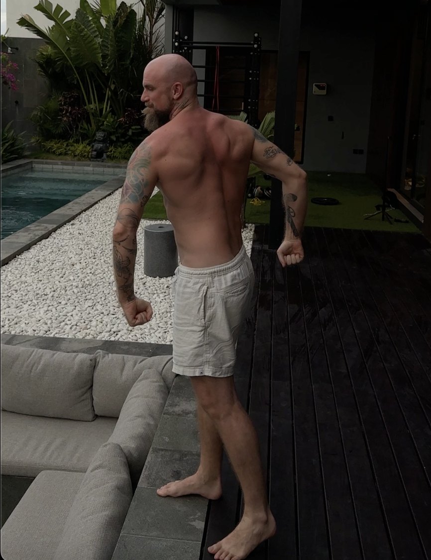 Justin photographed from behind now, with full back and shoulder muscle.