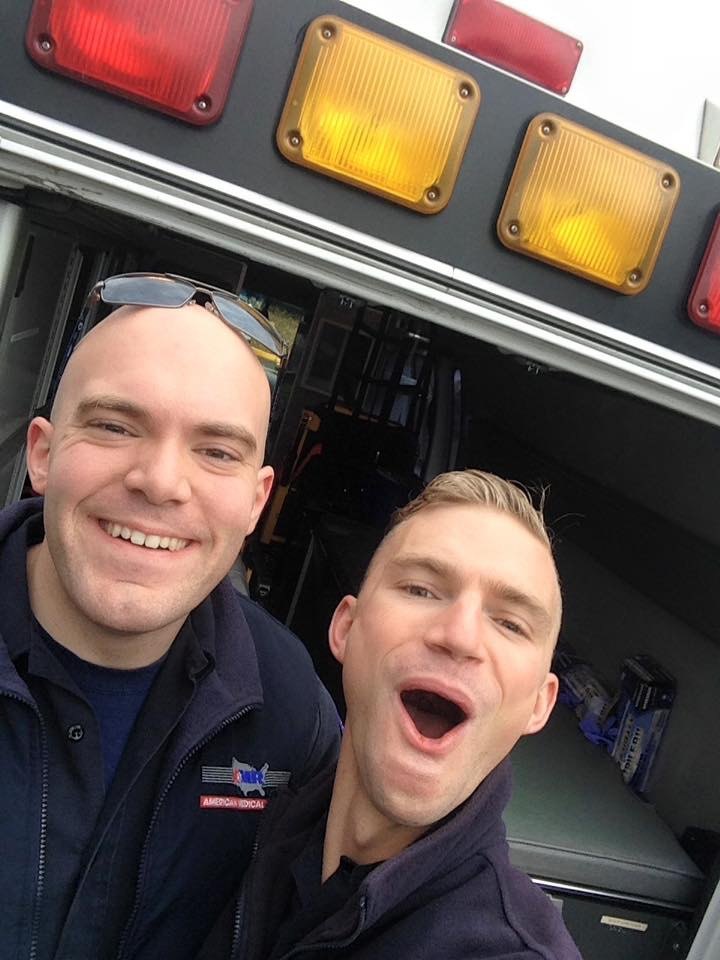 Justin in uniform at the back of an ambulance during his EMT years.